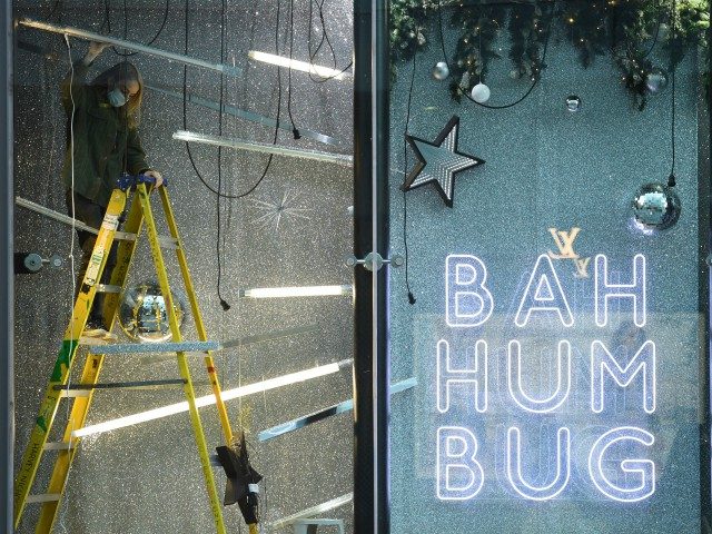 Workers install a festive Christmas-themed window display in a Harvey Nichols store in central Manchester, north west England on November 4, 2020, as the country prepares for a second Covid-19 lockdown in an effort to combat soaring infections. - England heads into a second national lockdown on November 5. (Photo ...