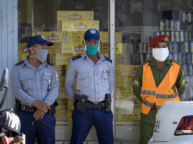 Police officers stand guard outside a store selling products in US dollars, in Havana on J