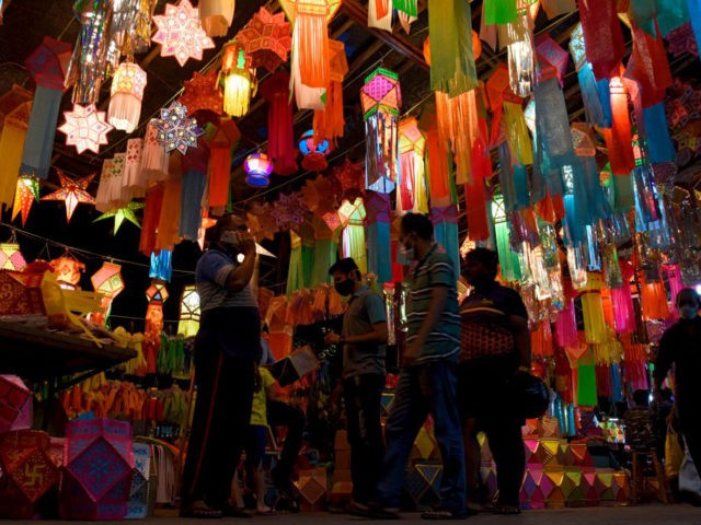 People shop in a market selling paper lanterns ahead of Diwali, the Hindu festival of ligh