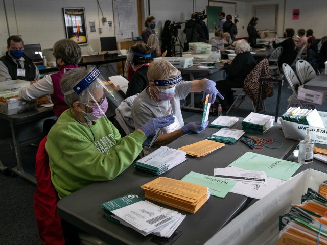 Election workers sort absentee ballot envelopes at the Lansing City Clerk's office on November 02, 2020 in Lansing, Michigan. For the first time, Michigan law is allowing clerks in Michigan cities to expedite the vote-counting process by removing secrecy envelopes from outer mailing envelopes one day ahead of the election. …