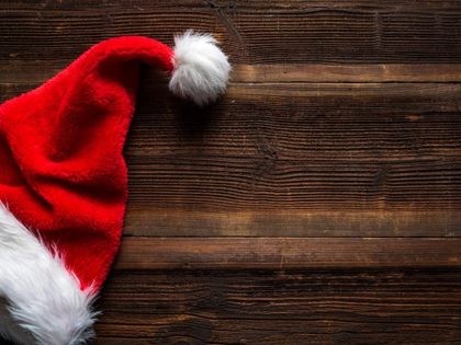 Santa red hat on wooden background, holiday Christmas concept.