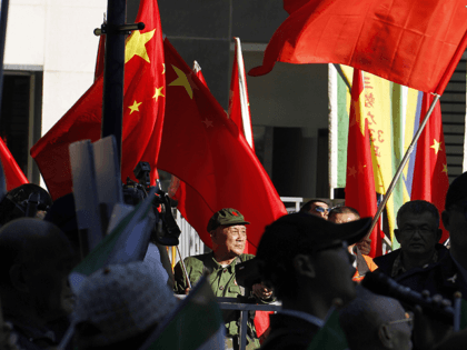 A pro-China demonstrator waves a Chinese flag outside where the Twin City Forum is being h