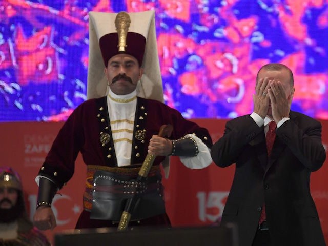 Turkish president Recep Tayyip Erdogan (R) prays next to a Turkish soldier wearing a ottoman uniform during a third anniversary commemoration rally at the Ataturk International Airport in Istanbul on July 15, 2019. - Turkey commemorates, on July 15, 2019 the third anniversary of a coup attempt which was followed …