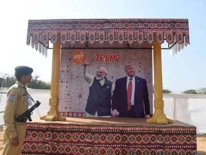 A police personnel from Gujarat Police Force looks at a billboard depicting India's Prime