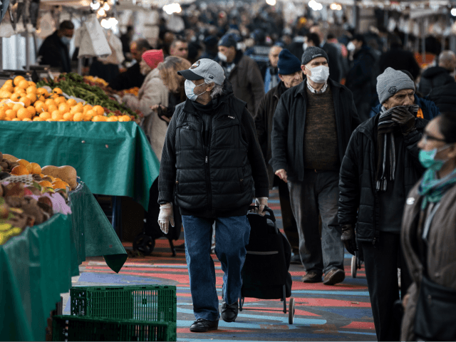 People wearing facemasks for protective measures do their grocery shopping at the Barbes Market, on March 18, 2020, in Paris, as a strict lockdown came into in effect in France to stop the spread of COVID-19, caused by the novel coronavirus. - A strict lockdown requiring most people in France …