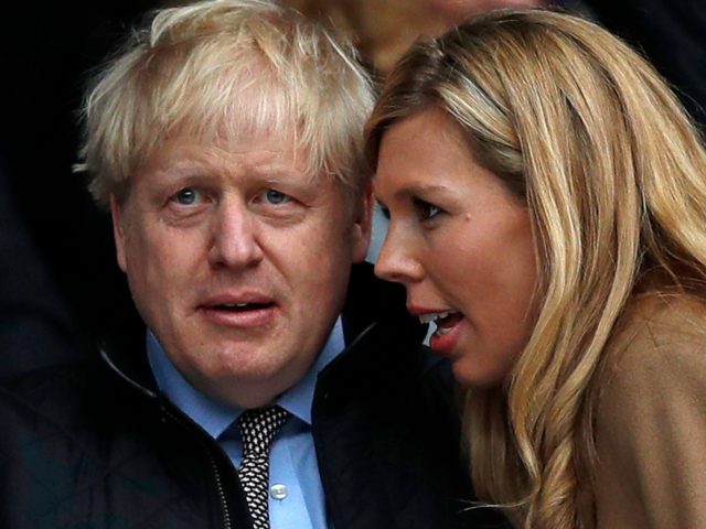 Britain's Prime Minister Boris Johnson (2R) with his partner Carrie Symonds (R) attend the Six Nations international rugby union match between England and Wales at the Twickenham, west London, on March 7, 2020. (Photo by ADRIAN DENNIS / AFP) (Photo by ADRIAN DENNIS/AFP via Getty Images)