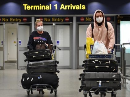 Passengers wearing PPE (personal protective equipment), including a face mask as a precautionary measure against COVID-19, arrive at Terminal 1 of Manchester Airport in northern England, on June 8, 2020, as the UK government's planned 14-day quarantine for international arrivals to limit the spread of the novel coronavirus begins. (Photo …