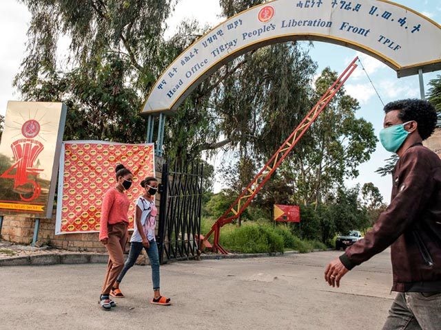 People walk in front of the head office of the Tigray Peoples Liberation Front (TPLF), the ruling party in the region, in the city of Mekele, northern Ethiopia, on September 6, 2020, ahead of the September 9 regional elections. - The region of Tigray prepares for the September 9 regional …
