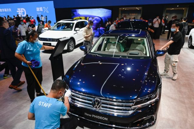 Two staffs clean a Volkswagen New Phideon car at the Beijing Auto Show in Beijing on September 26, 2020. (Photo by WANG Zhao / AFP) (Photo by WANG ZHAO/AFP via Getty Images)