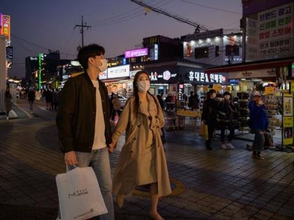 In a photo taken on October 18, 2020 people wearing face masks walk on a street in the Hongdae district of Seoul. (Photo by Ed JONES / AFP) (Photo by ED JONES/AFP via Getty Images)