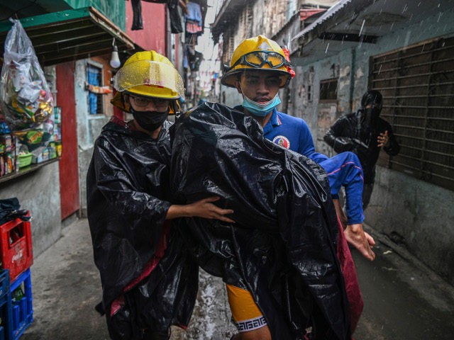 Rescue workers carry a child to a waiting vehicle during an evacuation of informal settler