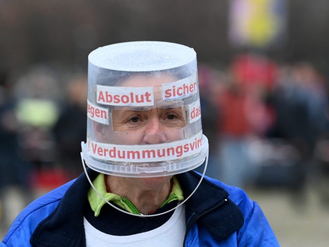 TOPSHOT - A participant wears a bucket as protection during a demonstration against the coronavirus Covid-19 restrictions in Munich, southern Germany, on November 1, 2020. (Photo by Christof STACHE / AFP) (Photo by CHRISTOF STACHE/AFP via Getty Images)