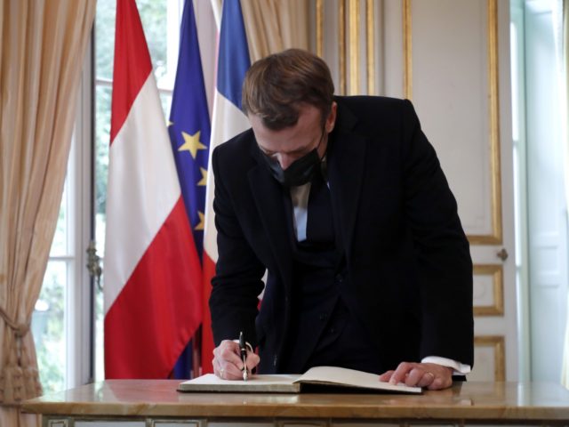 French President Emmanuel Macron signs a condolence book for victims of the Vienna attack