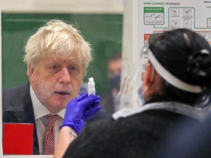 Britain's Prime Minister Boris Johnson (L) speaks with staff at a testing centre in De Montfort University, in Leicester, central England on November 6, 2020, as the second lockdown comes into force in England. - A united effort to tackle spiking coronavirus infection rates has been called for as 56 …
