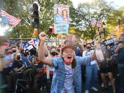 A woman dances after spraying prosecco onto the crowd as people celebrate on Black Lives M