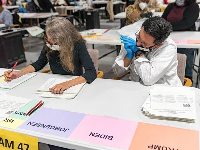LAWRENCEVILLE, GA - NOVEMBER 16: Gwinnett County election workers handle ballots as part of the recount for the 2020 presidential election at the Beauty P. Baldwin Voter Registrations and Elections Building on November 16, 2020 in Lawrenceville, Georgia. Officials are hoping to finish the hand counting of ballots before the …