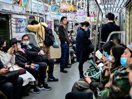 People wearing facemasks as a preventive measure against the Covid-19 coronavirus, commute late evening in Tokyo on November 17, 2020. (Photo by CHARLY TRIBALLEAU / AFP) (Photo by CHARLY TRIBALLEAU/AFP via Getty Images)
