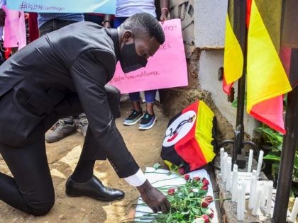 Ugandan musician turned politician Robert Kyagulanyi, also known as Bobi Wine, lays flowers during a prayer for the victims of the protest against his arrest at the headquarters of his opposition party, the National Unity Platform (NUP), in Kampala, Uganda, on November 21, 2020. - A Ugandan court on November …