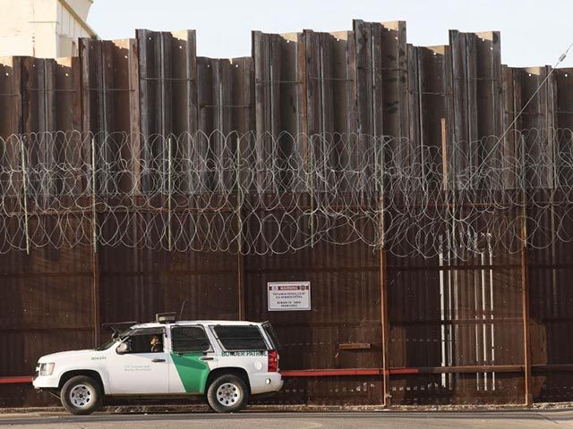 CALEXICO, CALIFORNIA - JULY 24: A Border Patrol agent is posted in front of the U.S.-Mexico border barrier in Imperial County, which has been hard-hit by the COVID-19 pandemic, on July 24, 2020 in Calexico, California. Imperial County currently suffers from the highest death rate and near-highest infection rate from …