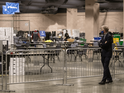 A man watches on from the observers area as election workers count ballots at the Philadelphia Convention Center on November 06, 2020 in Philadelphia, Pennsylvania. Joe Biden took the lead in the vote count in Pennsylvania on Friday morning from President Trump, as mail-in ballots continue to be counted in …