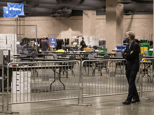 A man watches on from the observers area as election workers count ballots at the Philadel