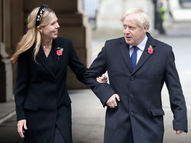 LONDON, ENGLAND - NOVEMBER 08: Britain's Prime Minister Boris Johnson with partner Carrie Symonds, on their way to meet veterans during the National Service of Remembrance at The Cenotaph on November 08, 2020 in London, England. Remembrance Sunday services are still able to go ahead despite the covid-19 measures in …