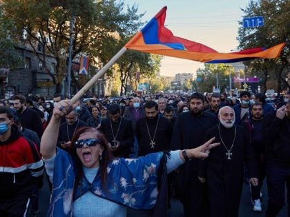 YEREVAN, ARMENIA - NOVEMBER 11: A woman waves an Armenian flag as protesters march to demand the removal of Armenian Prime Minister Nikol Pashinyan from office near the Armenian parliament building on November 11, 2020 in Yerevan, Armenia. The Russia-brokered deal, which Armenian Prime Minister Nikol Pashinyan called "incredibly painful …