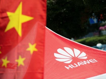 A logo of Huawei Technologies Co Ltd is seen next to a Chinese flag in Shanghai on October 1, 2014. The founder of Chinese telecommunications giant Huawei announced plans to invest 1.5 billion euros ($1.9 billion) in France to develop smartphones, the online edition of Les Echos business daily reported …
