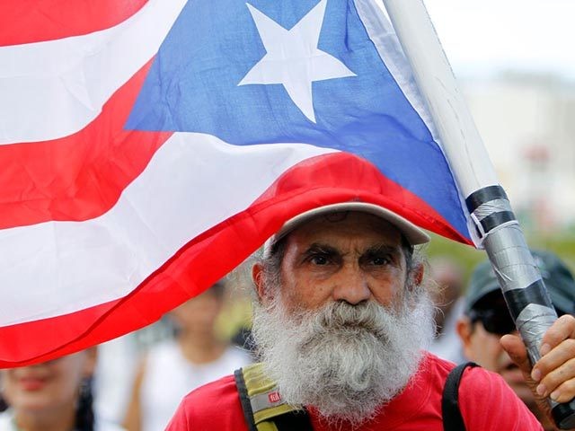 A man carries a Puerto Rican flag during a protest against the referendum for Puerto Rico
