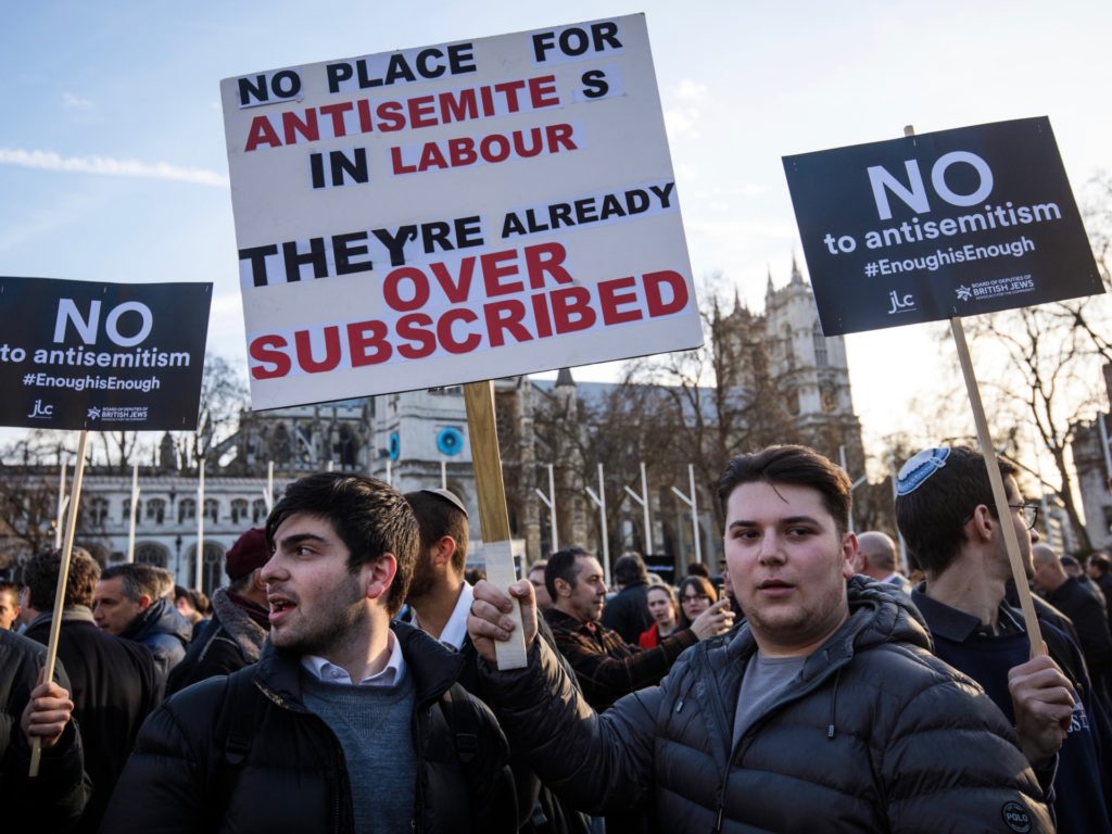 LONDON, ENGLAND - MARCH 26: Protesters hold placards as they demonstrate in Parliament Square against anti-Semitism in the Labour Party on March 26, 2018 in London, England. The Board of Deputies of British Jews and the Jewish Leadership Council have drawn up a letter accusing Labour Leader Jeremy Corbyn of failing to address anti-Semitism in his party. Mr Corbyn has today apologised to Jewish groups for "pockets of anti-Semitism" in Labour. (Photo by Jack Taylor/Getty Images)