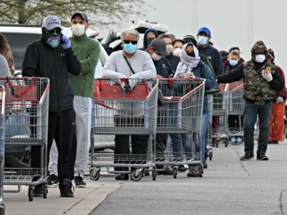 WHEATON, MARYLAND - APRIL 16: Customers wear face masks to prevent the spread of the novel coronavirus as they line up to enter a Costco Wholesale store April 16, 2020 in Wheaton, Maryland. Maryland Governor Larry Hogan ordered that all people must wear some kind of face mask to protect …