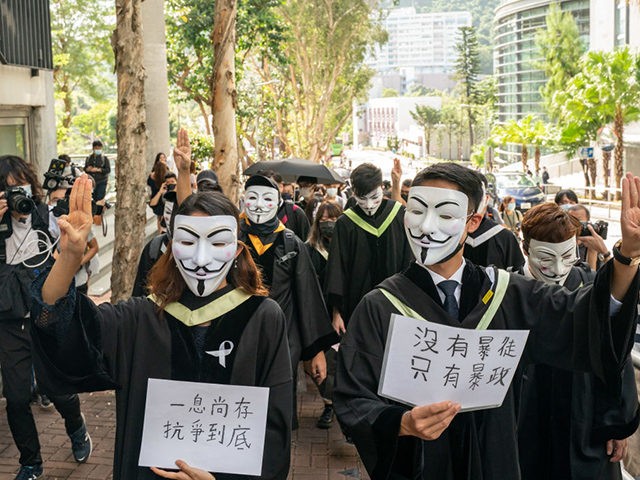 HONG KONG, CHINA - NOVEMBER 19: Students wearing black graduation gowns and Guy Fawkes masks march at the Chinese University of Hong Kong campus as they chant anti-government protest slogans and hold up banners and flags on November 19, 2020 in Hong Kong, China. Chinese University of Hong Kong students …