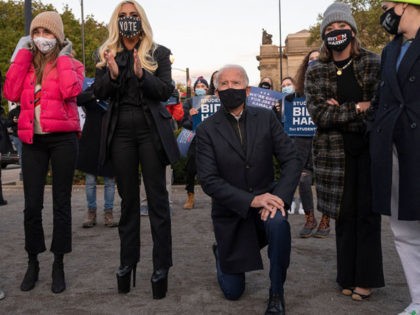 Democratic presidential candidate Joe Biden (C) kneels as he looks on with with Lady Gaga (3L) before a drive-in rally in Pittsburgh, Pennsylvania on November 2, 2020. - The US presidential campaign enters its final day Monday with a last-minute scramble for votes by Donald Trump and Joe Biden, drawing …