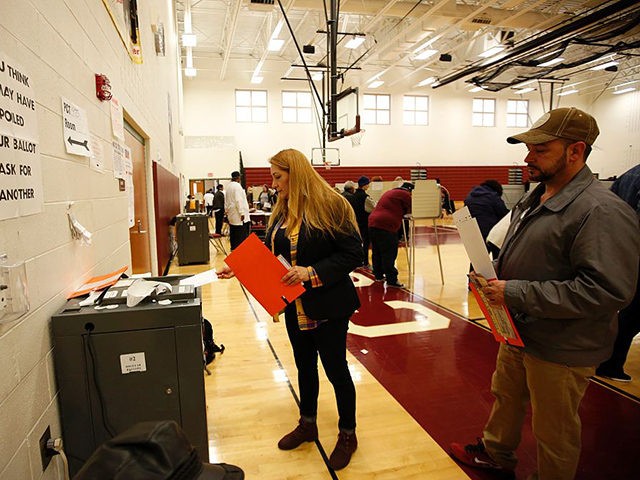 A woman places her ballot in the tabulation machine after voting at Western High School School in the US presidential election on November 8, 2016 in Detroit, Michigan. / AFP / JEFF KOWALSKY (Photo credit should read JEFF KOWALSKY/AFP via Getty Images)