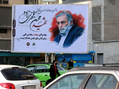 Vehicles drive by a billboard in honour of slain nuclear scientist Mohsen Fakhrizadeh in t