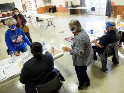 LUMBERTON, NC - NOVEMBER 03: A voter receives instructions from volunteers for voting at t