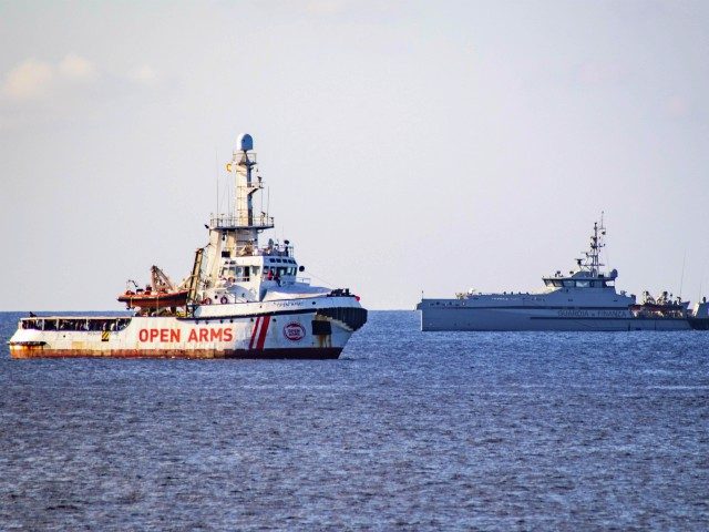 The Italian Guardia di Finanza boat sails towards the Spanish migrant rescue NGO ship Open Arms to retrieve 27 unaccompanied minors and take them to the Italian island of Lampedusa on August 17, 2019. - Twenty-seven unaccompanied minors have been authorised to leave a migrant rescue vessel in limbo off …