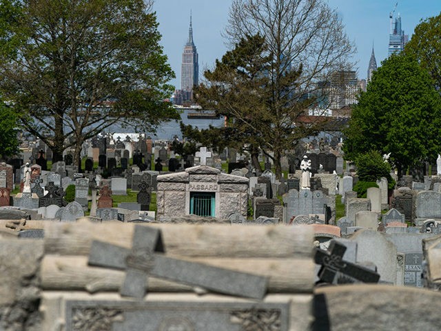 NEW YORK, NY - MAY 10: The Empire State Building is seen behind the tombstones at Calvary Cemetery on May 10, 2020 in the Queens borough of New York City. The Catholic Archdiocese of New York is opening COVID-related cemetery-visitation restrictions for Mothers Day. (Photo by Jeenah Moon/Getty Images)