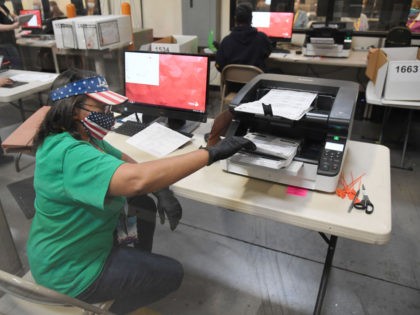 NORTH LAS VEGAS, NEVADA - NOVEMBER 07: A Clark County election worker scans mail-in ballot