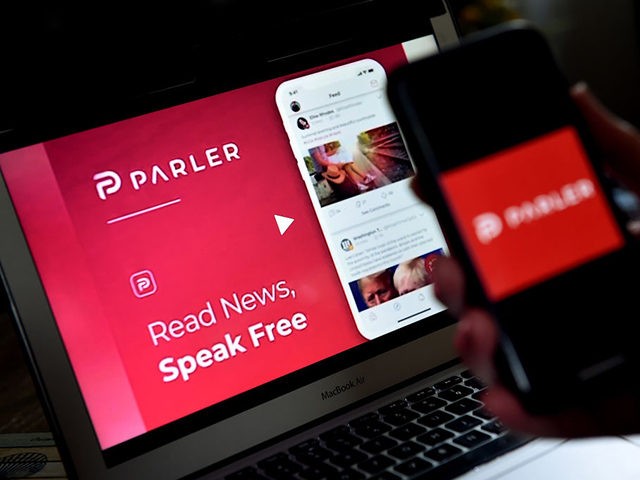 This illustration picture shows social media application logo from Parler displayed on a smartphone with its website in the background in Arlington, Virginia on July 2, 2020. - Amid rising turmoil in social media, recently formed social network Parler is gaining with prominent political conservatives who claim their voices are …