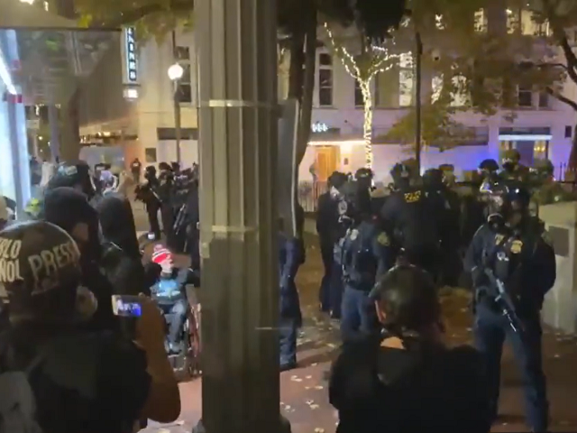 Anti-police Antifa protesters cheer cops after they detain an armed counter protester. (Tw