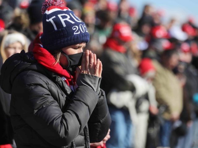 DUBUQUE, IOWA - NOVEMBER 01: A woman prays as supporters of President Donald Trump congregate before his arrival at a campaign rally at Dubuque Regional Airport on November 1, 2020 in Dubuque, Iowa. With two days to go before Election Day, President Trump and Democratic presidential nominee Joe Biden continue …
