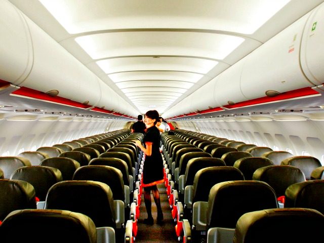 A flight attendant walks the aisle of a new Jetstar Asia Airbus A320 Wednesday, Nov. 10, 2004 in Singapore. Jetstar Asia, a Quantas venture, which had its first plane delivered today is the newest entrant to the region's already crowded budget airline market.(AP Photo/Ed Wray)