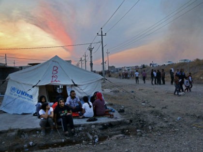 Syrians, who have been recently-turned refugees by the Turkish military operation in northeastern Syria, sit together outside a tent at the Bardarash camp, near the Kurdish city of Dohuk, in Iraq's autonomous Kurdish region, on October 18, 2019. - Over two thousand people, mostly women and children, have fled fighting …
