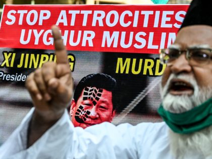 Muslims hold a placard displaying the picture of China's President Xi Jinping as they protest against the Chinese government's policies on Muslim Uighur minorities, in Mumbai on November 12, 2020. (Photo by Punit PARANJPE / AFP) (Photo by PUNIT PARANJPE/AFP via Getty Images)