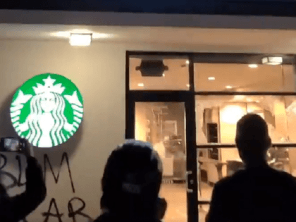 Rioters in Portland prepare to set fire to a Starbucks located below a mid-rise apartment building. (Twitter Video Screenshot)