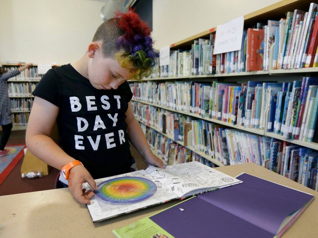In this Wednesday, July 12, 2017 photo, Sam, 9, reads a book in the library at Bay Area Rainbow Day Camp in El Cerrito, Calif. The camp caters to transgender and "gender fluid" children, aged 4-12, making it one of the only camps of its kind in the world open …