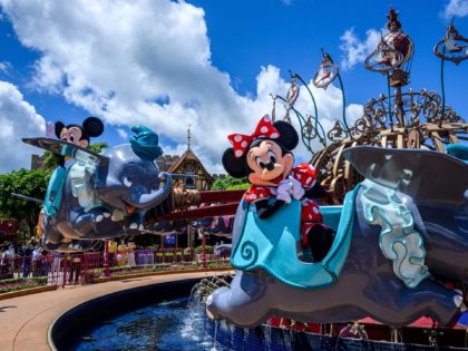 Cast members dressed as cartoon characters Minnie Mouse (R) and Mickey Mouse (L) sit on a