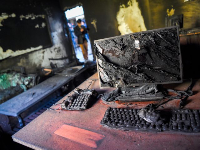 A photographer takes pictures inside a burned office of the National Legal Training center