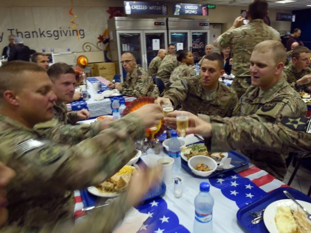 US soldiers cheer during a Thanksgiving Day meal at the International Security Assistance Force (ISAF) headquarters in Kabul on November 27, 2014. The meal was served to mark the US celebration of the Thanksgiving Day holiday. AFP PHOTO/SHAH Marai (Photo credit should read SHAH MARAI/AFP via Getty Images)